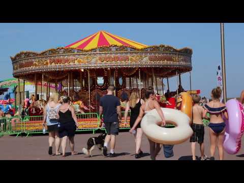 People walking towards a carousel.